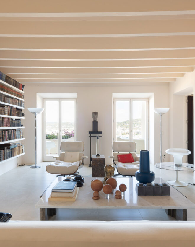 Colourful artwork and a wall of books flank the contemporary living space of a luxury townhouse for sale in Ibiza
