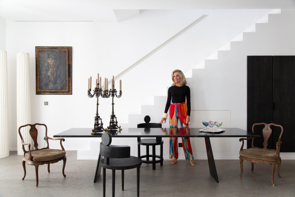 Woman stands next to a grand dining table in an Ibizan townhouse
